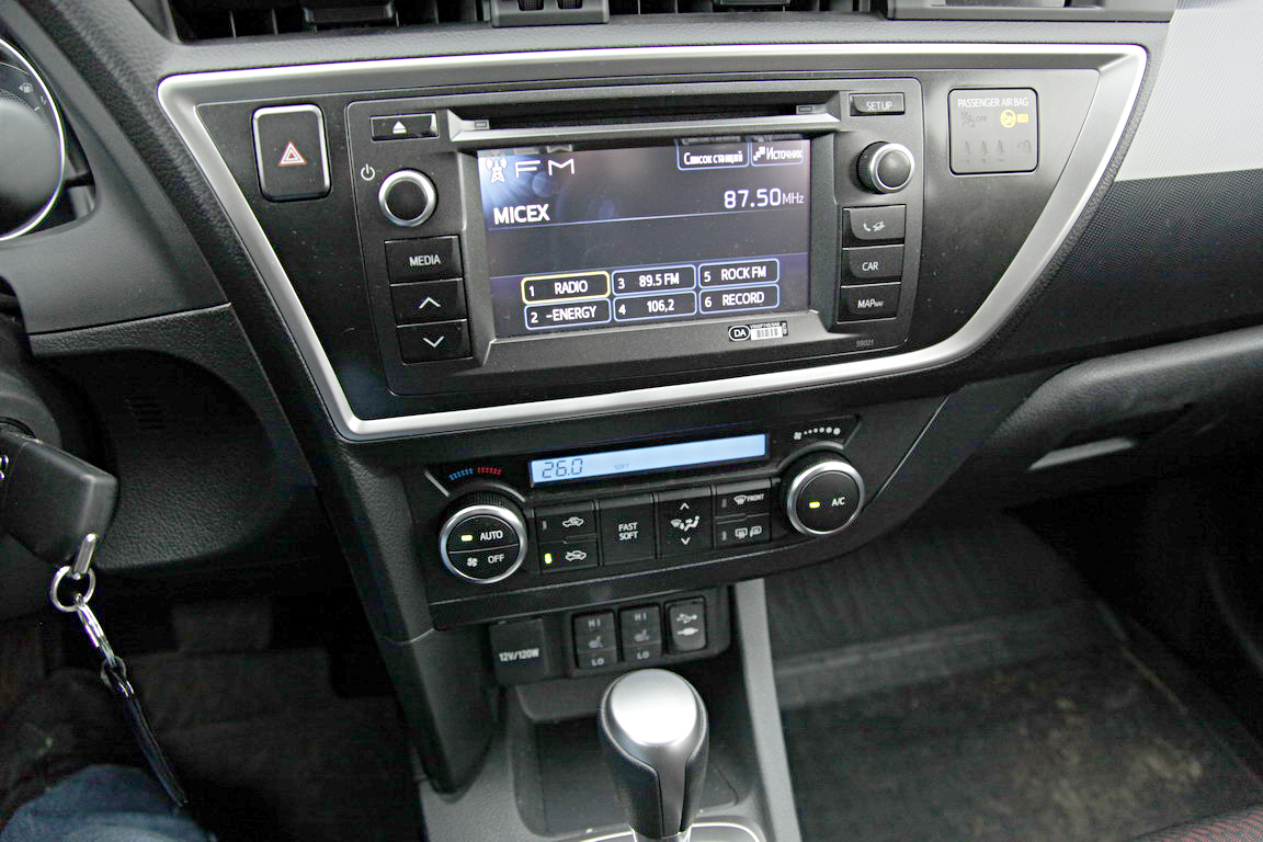 Дешевый пластик торпедо Toyota Auris живо перекликается с унылой синей подсветкой, монохромными часами и индикатором климат-контроля, но не с передовой внешностью хэтчбека